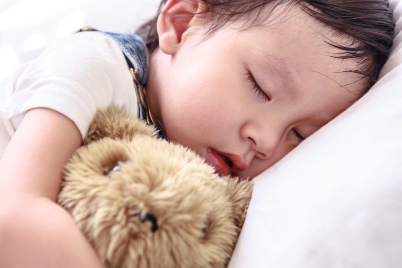 When can stuffed animals or blankets be safely introduced in the crib?